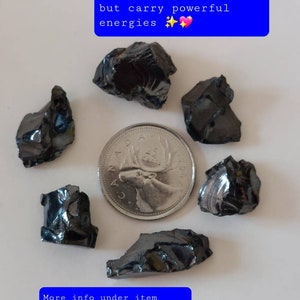 K&ouml;nnte beinhalten: Sechs kleine, dunkelgraue Shungit-Steine, die jeweils zwischen 0 und 2 Gramm wiegen, sind um eine kanadische 25-Cent-M&uuml;nze angeordnet. Der Text "These beautiful high grade Shungites are small 0-2 grams each, but carry powerful energies" ist &uuml;ber den Steinen zu sehen. Der Text "More info under item description in listing and under FAQs in store" ist unter den Steinen zu sehen.