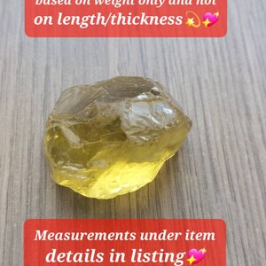 K&ouml;nnte beinhalten: Ein rauer, gelbbrauner Edelstein auf einer Holzoberfl&auml;che. Der Text "Rough stones are classified based on weight only and not on length/thickness" befindet sich &uuml;ber dem Stein. Der Text "Measurements under item details in listing" befindet sich unter dem Stein.
