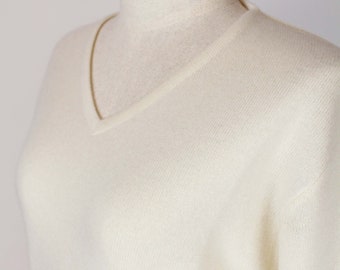 May include: A white v-neck sweater on a white mannequin.