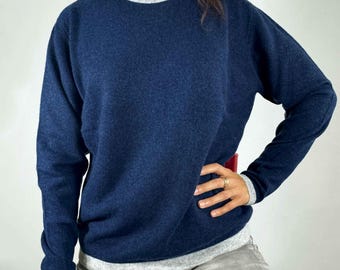 Könnte beinhalten: Ein marineblauer Langarm-Pullover mit einem grauen Saum an Ausschnitt und unterem Saum.