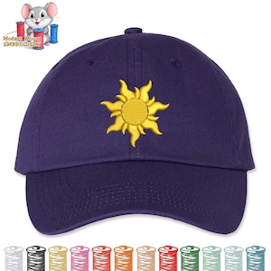 May include: A dark purple baseball cap with a yellow embroidered sun design. The cap has a curved brim and a fabric strap closure. The sun design is centered on the front of the cap.