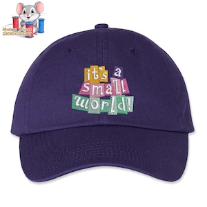 May include: A navy blue baseball cap with an embroidered design that says "it's a small world!" in colorful block letters.
