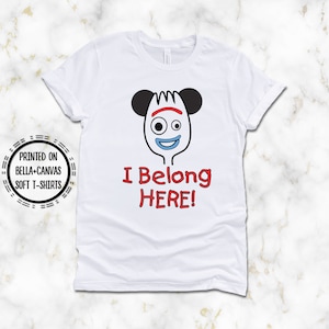 May include: White t-shirt with a cartoon image of a fork with Mickey Mouse ears and the text "I Belong HERE!"