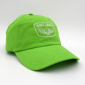 May include: A bright green baseball cap with a white embroidered logo that says "SPACE RANGER" with a rocket ship and wings inside a white rectangle.