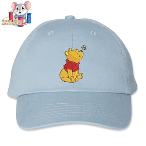 May include: A light blue baseball cap with an embroidered image of Winnie the Pooh looking up at a bee.