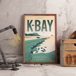 May include: A vintage-style poster with a teal and beige color scheme. The poster features a graphic illustration of a beach scene with a surfer, a rocky coastline, and a setting sun. The text on the poster reads "DORSET K-BAY JURASSIC COAST".