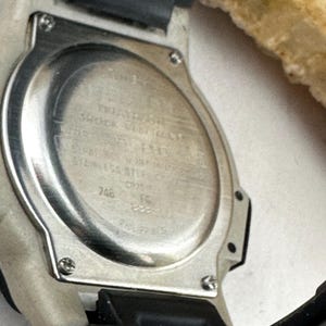 May include: A white ceramic mug with a black handle and the text "But First, Coffee" in a black, bold font. The mug is sitting on a white surface.