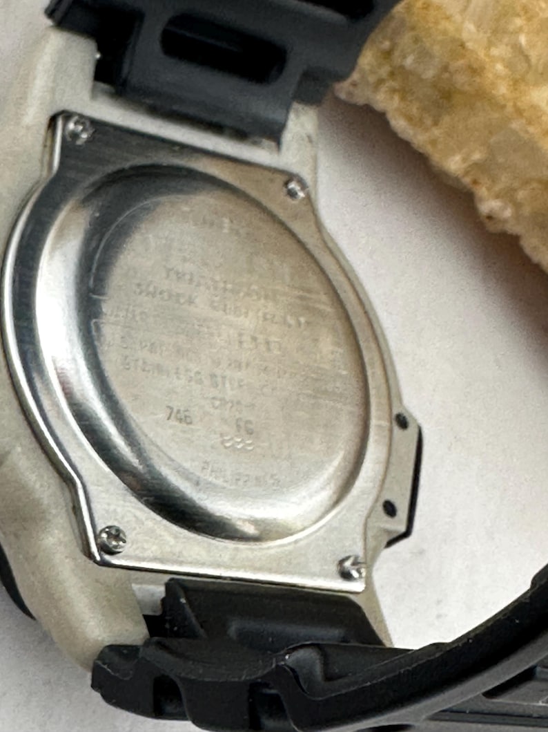 May include: A white ceramic mug with a black handle and the text "But First, Coffee" in a black, bold font. The mug is sitting on a white surface.