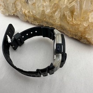 May include: A set of three ceramic mugs with a speckled, matte finish. The mugs are in shades of cream, light gray, and dark gray. Each mug has a simple, minimalist design and a rounded handle. The mugs are stacked on top of each other.