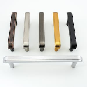 Puede incluir: Un juego de seis tiradores de armario en varios acabados, incluyendo níquel cepillado, bronce aceitado, negro, oro y cromo. Los tiradores tienen un diseño simple y moderno con una forma ligeramente curvada.