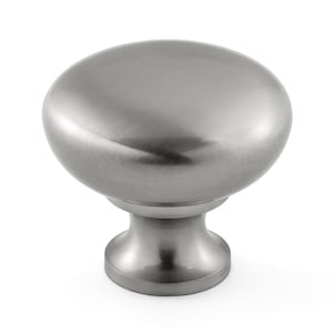 May include: A round cabinet knob with a brushed silver finish. The knob features a smooth, domed top surface that transitions into a tapered, cylindrical base. The metallic surface reflects light, highlighting the circular shape and texture.