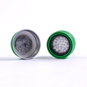 May include: Two green and silver water filter caps, one with a white filter and the other with a gray filter.