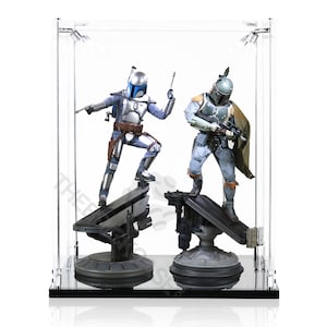May include: Two Star Wars action figures, Boba Fett and a blue Mandalorian, are displayed in a clear acrylic display case. Both figures are standing on black bases with a silver and gray design.
