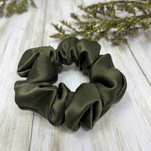 May include: A dark green satin scrunchie for hair.