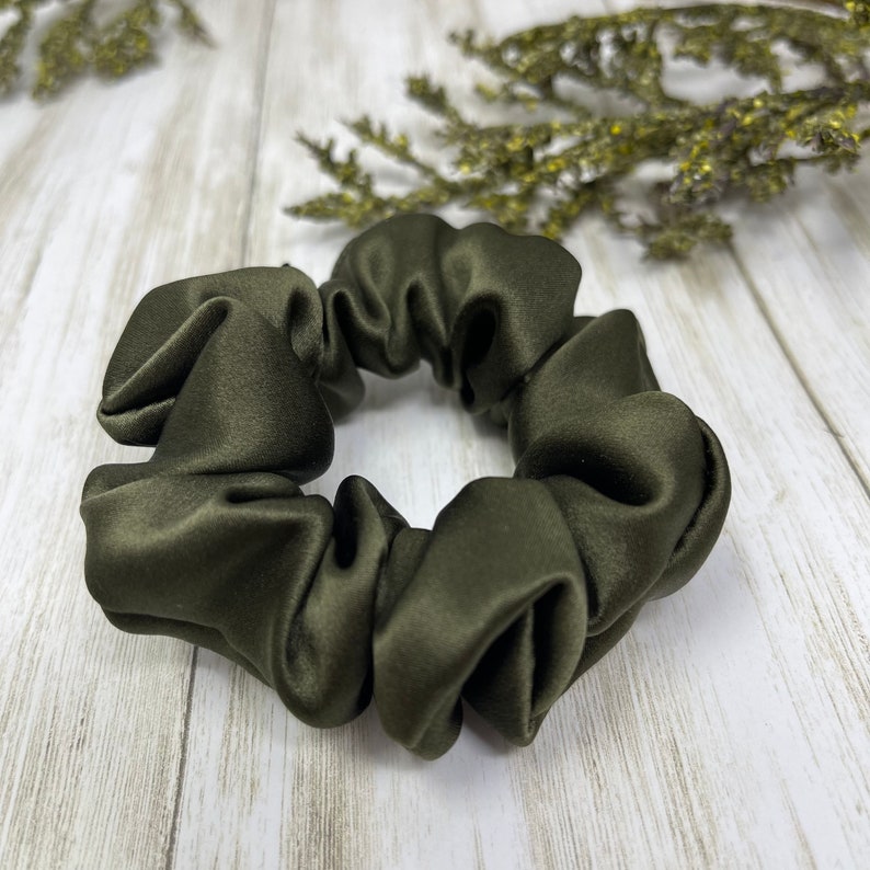May include: A dark green satin scrunchie for hair.
