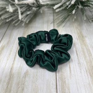 May include: A dark green, 100% silk scrunchie for hair.