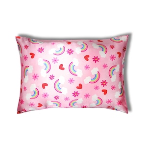 May include: Pink pillowcase with a repeating pattern of rainbows, white clouds, red hearts, and pink flowers. The pillowcase is rectangular and has a satin finish. The design is whimsical and colorful.