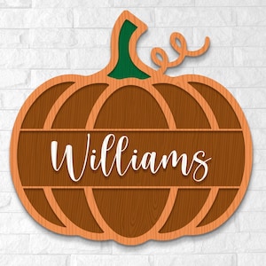 May include: A two-layer wooden pumpkin decoration with the name "Williams" in white script. The pumpkin has a brown wood grain appearance with orange outlines and a green stem. Perfect for fall decor.