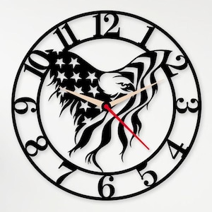 May include: Black metal wall clock featuring an eagle design with the American flag incorporated into the wings. The clock has a circular shape with black numerals and hands, and a red second hand. The clock is a decorative item.