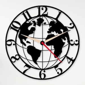 May include: A black and white wall clock with a world map design. The clock features a circular frame with numbers and a globe silhouette in the center. The hands are beige and red. The clock measures approximately 12 inches in diameter.