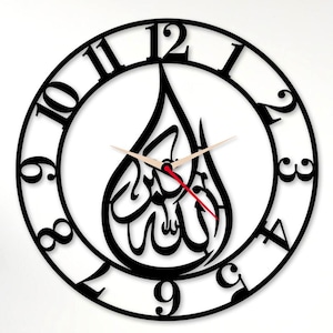 May include: Black, circular wall clock with Arabic calligraphy inside a teardrop shape. The clock has a black frame with white numbers and hands, and a red second hand. The clock is on a white wall.