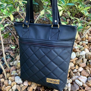 May include: Black quilted tote bag with gold hardware and a gold label that says "OMMO".