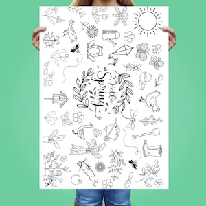May include: A black and white poster with spring-themed illustrations. The design includes a sun, flowers, insects, and the words "Hello Spring" in a decorative font. The poster is held up by a person.