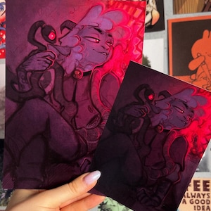 May include: Two purple and pink illustrations of a furry creature with a collar and a smaller creature with glowing red eyes. The illustrations are in a dark, shadowy style with a red glow around the edges.
