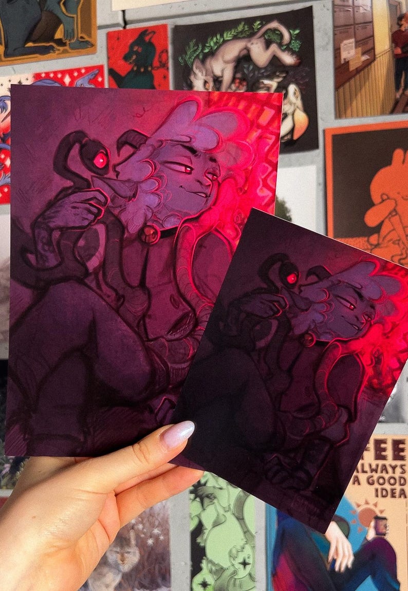 May include: Two purple and pink illustrations of a furry creature with a collar and a smaller creature with glowing red eyes. The illustrations are in a dark, shadowy style with a red glow around the edges.