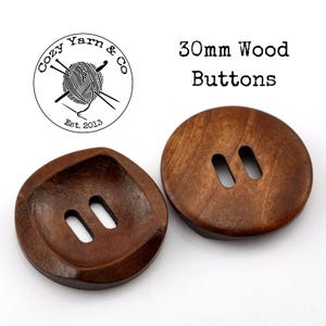 May include: Two brown wooden buttons, each with two holes. The buttons are 30mm in diameter. The text "30mm Wood Buttons" is visible above the buttons.