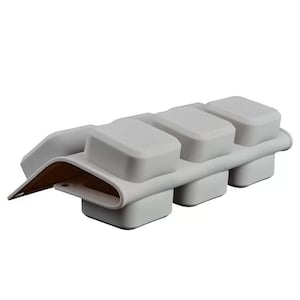 May include: Gray silicone mold with four square cavities for making chocolate or other treats.