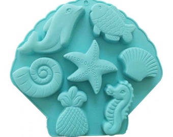 May include: A blue silicone mold shaped like a seashell with six different sea-themed designs: a dolphin, a fish, a starfish, a seashell, a pineapple, and a seahorse.