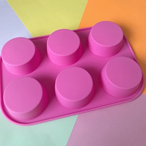 May include: Pink silicone mould with six round cavities for making small cakes or other treats.