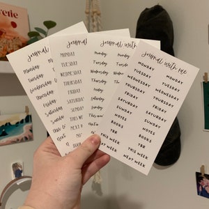 May include: Four white cards with black text. The cards are labeled "Journal", "Journal", "Journal with", and "Journal with me". Each card has a list of days of the week, including "Monday", "Tuesday", "Wednesday", "Thursday", "Friday", "Saturday", and "Sunday". Some cards also have additional text, such as "Notes", "Books", "TBR", "This Week", and "Next Week".