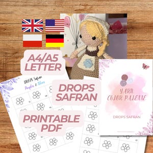 May include: A handmade crochet doll with a bonnet and apron, alongside printable PDF patterns and a yarn color palette. The image includes the text "DROPS SAFRAN" and "PRINTABLE PDF". The doll is set against a wooden background.