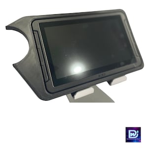 Puede incluir: Una tableta negra con una funda protectora y un soporte. La pantalla de la tableta es negra y la funda tiene un recorte para la cámara. El soporte es plateado y tiene un logotipo que dice "ACES".