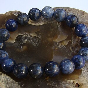May include: A blue gemstone bracelet with round beads. The bracelet is made of natural stones and is a beautiful piece of jewelry.