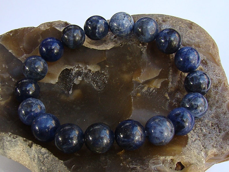 May include: A blue gemstone bracelet with round beads. The bracelet is made of natural stones and is a beautiful piece of jewelry.