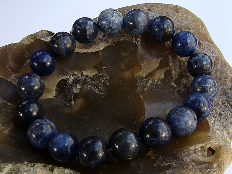 May include: A blue gemstone bracelet with round beads. The bracelet is made of natural stones and is a beautiful accessory for any occasion.