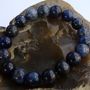 May include: A blue gemstone bracelet with round beads. The bracelet is made of natural stones and is a beautiful accessory for any occasion.
