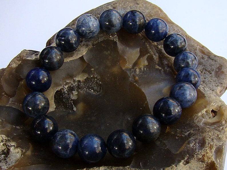 May include: A blue gemstone bracelet with round beads. The bracelet is made of natural stones and is a beautiful accessory for any occasion.