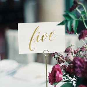 Elegante gouden tafelnummers voor bruiloften – Naamkaartjes tafels en briefpapier voor receptiedecoratie