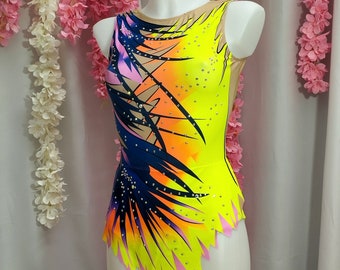 May include: A yellow, pink, orange, and blue leotard with a geometric design. The leotard has a scoop neck and a sleeveless design. The leotard is decorated with rhinestones.