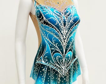 Puede incluir: Maillot sin mangas en tonos azul y turquesa, adornado con un diseño floral blanco estilizado. El corpiño presenta un escote de malla color piel y está adornado con pequeños acentos brillantes. El maillot se exhibe en un maniquí.