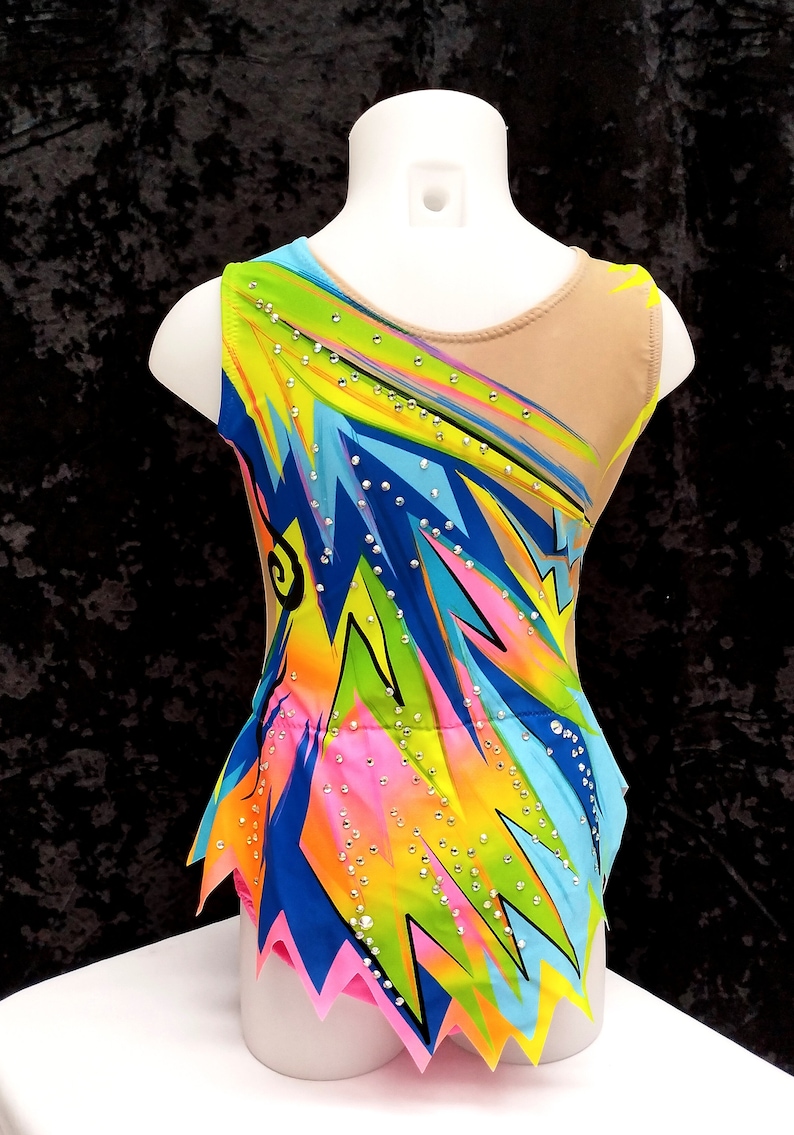 May include: A colorful gymnastics leotard with a vibrant design. The sleeveless garment features a mix of neon green, yellow, blue, and pink geometric patterns, embellished with sparkling rhinestones. The back and shoulder straps are nude-colored.