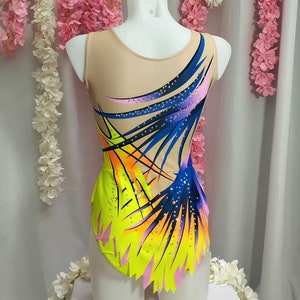 May include: A yellow, pink, blue, and orange leotard with a geometric design. The leotard has a scoop neck and a sleeveless design. The leotard is decorated with rhinestones.