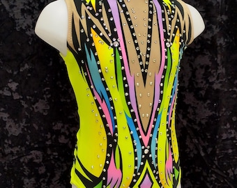 May include: A yellow, black, pink, and blue leotard with a geometric design and rhinestones. The leotard has a scoop neck and a sleeveless design.