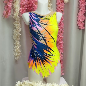 May include: A yellow, pink, blue, and orange leotard with a palm tree print and rhinestones. The leotard has a scoop neck and a sleeveless design.