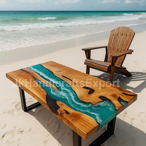 May include: A rectangular wooden coffee table with a turquoise resin river design, supported by black metal legs. The table is on a sandy beach with a wooden Adirondack chair in the background. The text "kHandicraftsExport" is visible on the table.