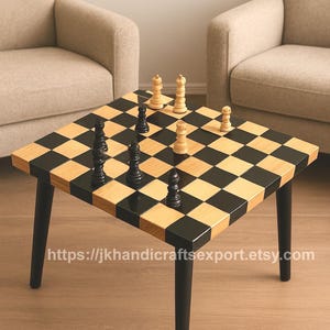 Peut inclure: Une table d'échecs carrée avec un plateau en damier noir et bois naturel. Des pièces d'échecs noires et blanches sont disposées sur le plateau. La table a des pieds noirs et l'URL de la boutique Etsy est visible.